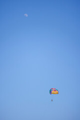 tourists parasailing on a sea seen against the clear blue sky