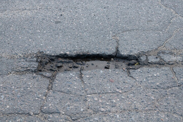 Pothole and Cracks on an Asphalt Road