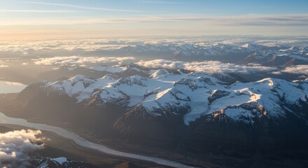 Aerial view of snow-covered mountains and a river valley under a serene sky