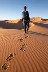 footprints of man in shoes walking in sand dunes of Sahara desert