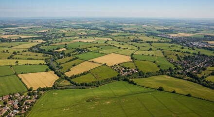 Aerial view of farmland showcasing patchwork fields and a meandering river on sunny day
