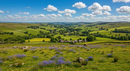 Obraz premium Rolling green hillsides with scattered houses and a vibrant blue floral foreground