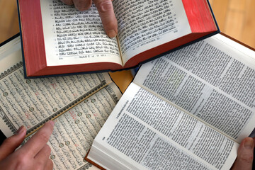 Three monotheistic religions. A Christian, a Jew, and a Muslim reading the Bible, the Torah, and...