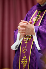 Catholic mass. Bishop praying. Close up on hands.  Saint Pierre et Paul church.  Saint Julien en...