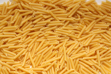 Uncooked Penne Pasta. Dry Pasta. Raw Macaroni - Top View, Flat Lay.