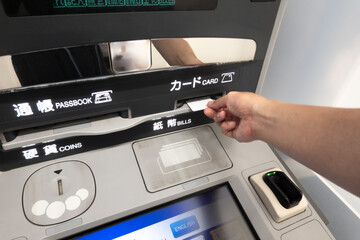 ATMに現金を投入するシーン ネット詐欺犯罪のイメージ