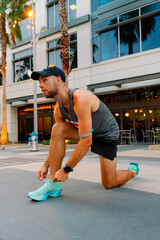 Athletic Man Tying Running Shoes Before Outdoor Workout in Urban Setting