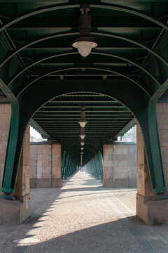 Two People Walking Through the Arched Pedestrian Walkway of the Oberbaum Bridge in Berlin