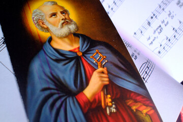 Catholic mass. Mass book with hymns and a religious image. Saint Peter with the keys.  Kontum. Vietnam.