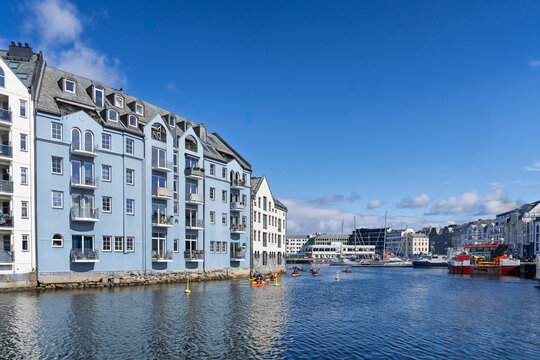 Colorful Waterfront Houses with Recreational Activity Under Clear Blue Sky, Aalesund, Norway