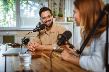 man and woman host and guest in podcast at home studio