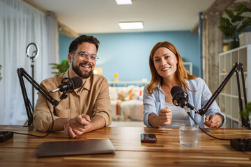 Portrait of man and woman host and guest in podcast at home studio