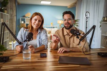 Portrait of man and woman host and guest in podcast at home studio