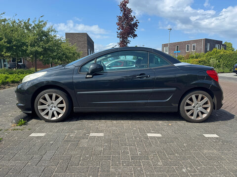 Almere, the Netherlands - June 10, 2025: Black Peugeot 207 cc parked by the side of the road. Nobody in de vehicle.