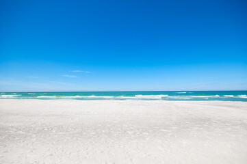 Sandy beach and sea waves by sunny summer day