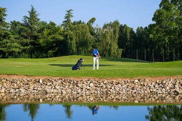 Golfer swinging his club on a sunny day at the golf course