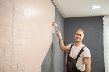 Man Painting Wall With Paint Roller