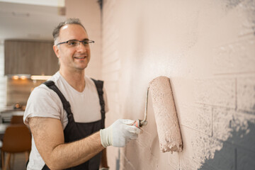 Man Painting Wall With Paint Roller
