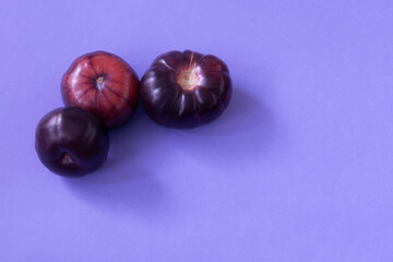 purple tomatoes on blue background top view