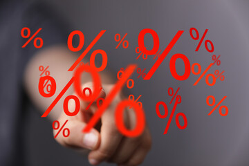 Hand pointing at percentage signs. Concept for interest rates, discounts, sales, finance, banking,...