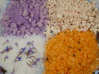 Obraz na płótnie Canvas Aromatic relaxing herbal and floral sea bath salt, various dried plants for making aromatic salt are on a blue background, top view
