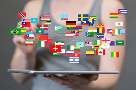 Person interacting with a digital network of global flags on a tablet.  Concept of international connection and communication.