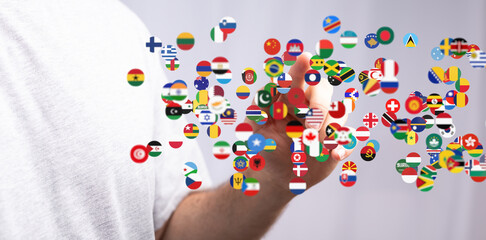 Image depicts a hand interacting with a digital display of numerous national flags, symbolizing global connections.