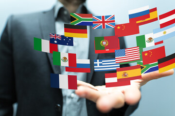 Image of a businessman holding various national flags, symbolizing international business and...