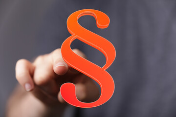 Image of a hand interacting with a 3D paragraph symbol, perfect for legal, law, and justice related...