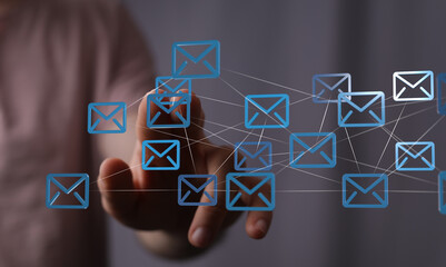 Hand interacting with a digital network of email icons.  Modern communication.