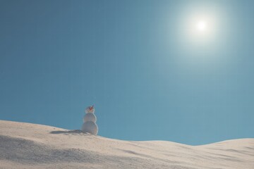 Snowman stood alone on a snowy dune under the bright sun, depicting an unusual weather scenario