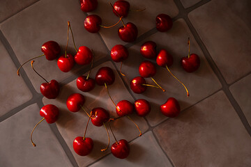 Many Red Fresh Dark Cherries on Gray Tile Background. Ripe Berry Fruit. Healthy Eating and Summer Dessert.