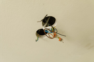 Image of exposed electrical wires in ceiling holes.  Needs repair. DIY home improvement.
