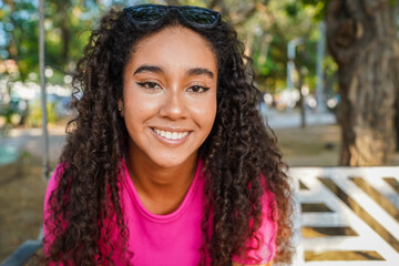 Young latin woman smiling in a park