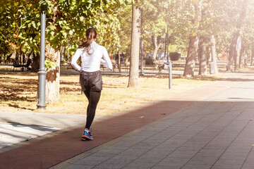 Woman Running on Path in Sunlit Park