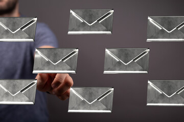 Hand selecting an email from a digital inbox, showcasing email management and communication.