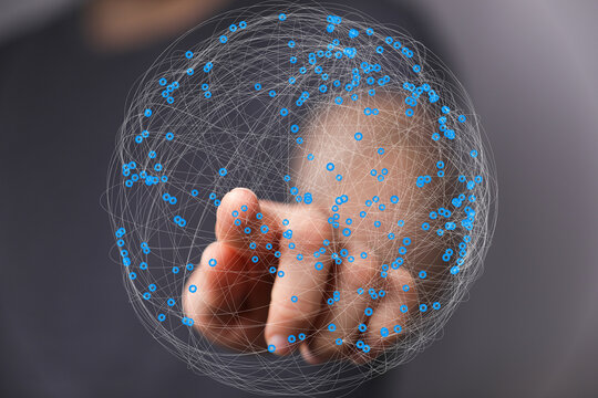 Abstract image of a hand interacting with a digital sphere representing global network connections and data visualization.
