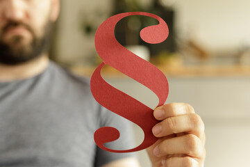 Stock photo of a man holding a red paragraph symbol.  Perfect for legal, law, or writing concepts.