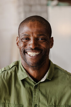 Senior African American man smiling gently and showing confidence in bright room headshot