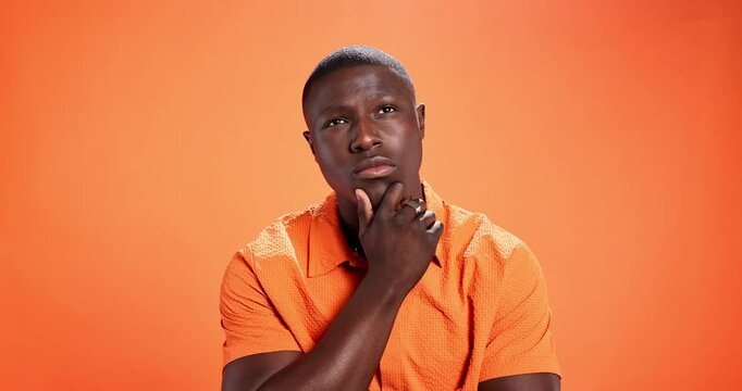 Memory, planning and thinking with black man on studio background for problem solving or solution. Future, ideas and wondering with African person on orange wall for contemplation or question