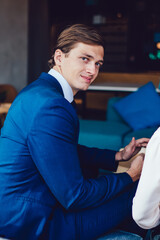 Cheerful businessman during conversation with colleague at hall