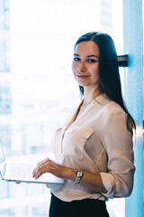Pensive executive woman using laptop in light office
