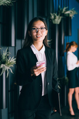 Asian businesswoman using cellphone at workplace