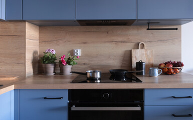 modern wooden kitchen in blue tones with flowers and fruits