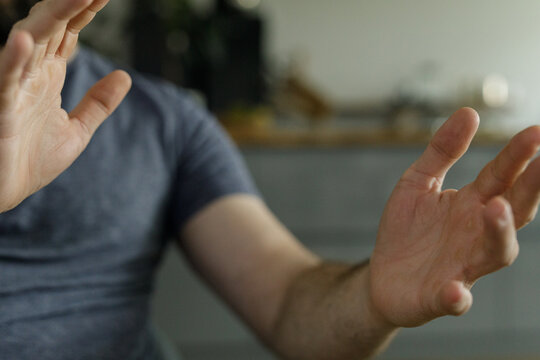 Close-up of a man's hands gesturing, conveying a sense of refusal, denial, or stopping.