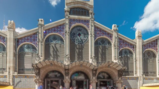 Valencia Central Market timelapse hyperlapse. Historic public market with stunning architecture, stained glass, dome and tile details. Located in Market Square near Santos Juanes Church. Spain