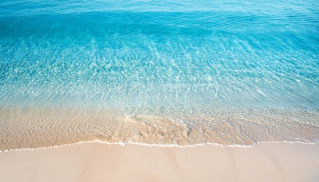 fresh blue and transparent water wave texture at sand beach from abobe sunny abstract water background with copy space for travel vacations and cosmetics nature scene in summertime