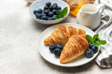 Delicious french croissants with fresh blueberries and honey for breakfast