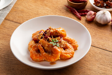 Crispy Prawn in Tamarind Glaze.Pan grilled shrimp topped with tamarind sauce,crispy shallot, and dry chili in white plate.Thai food.