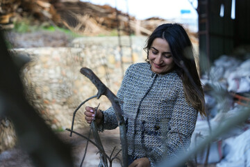 Woman Observes Bay Laurel Branches in Open Air Before Processing.